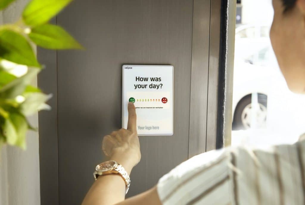 woman touching a feedback screen on a door