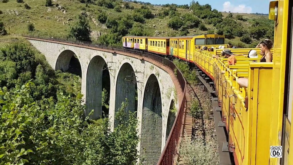 yellow touristic train on a scenic rail route in france