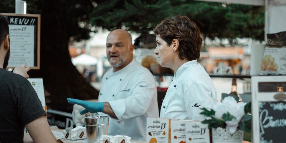 two local chefs showing off their products at a food festival