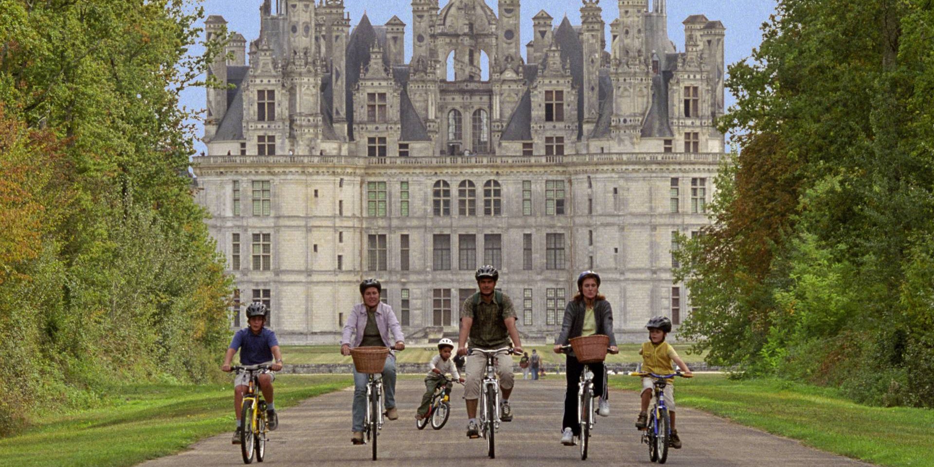 a family riding bicycles in front of a french castle