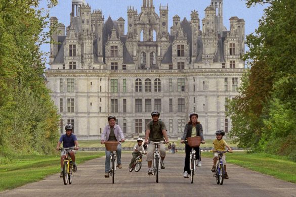 a family riding bicycles in front of a french castle