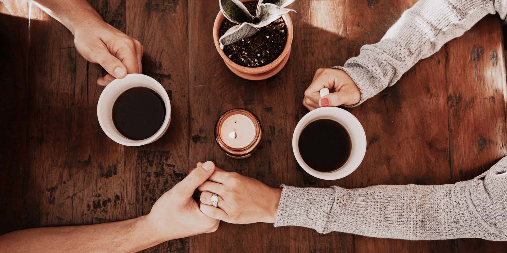 a couple holding hands drinking coffee