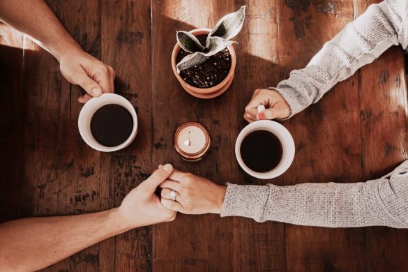 a couple holding hands drinking coffee