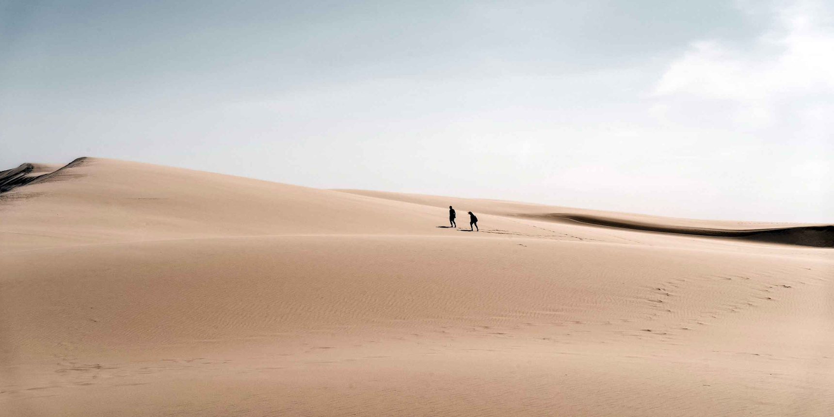 Two people crossing the Dune du Pilat seven wonders of france
